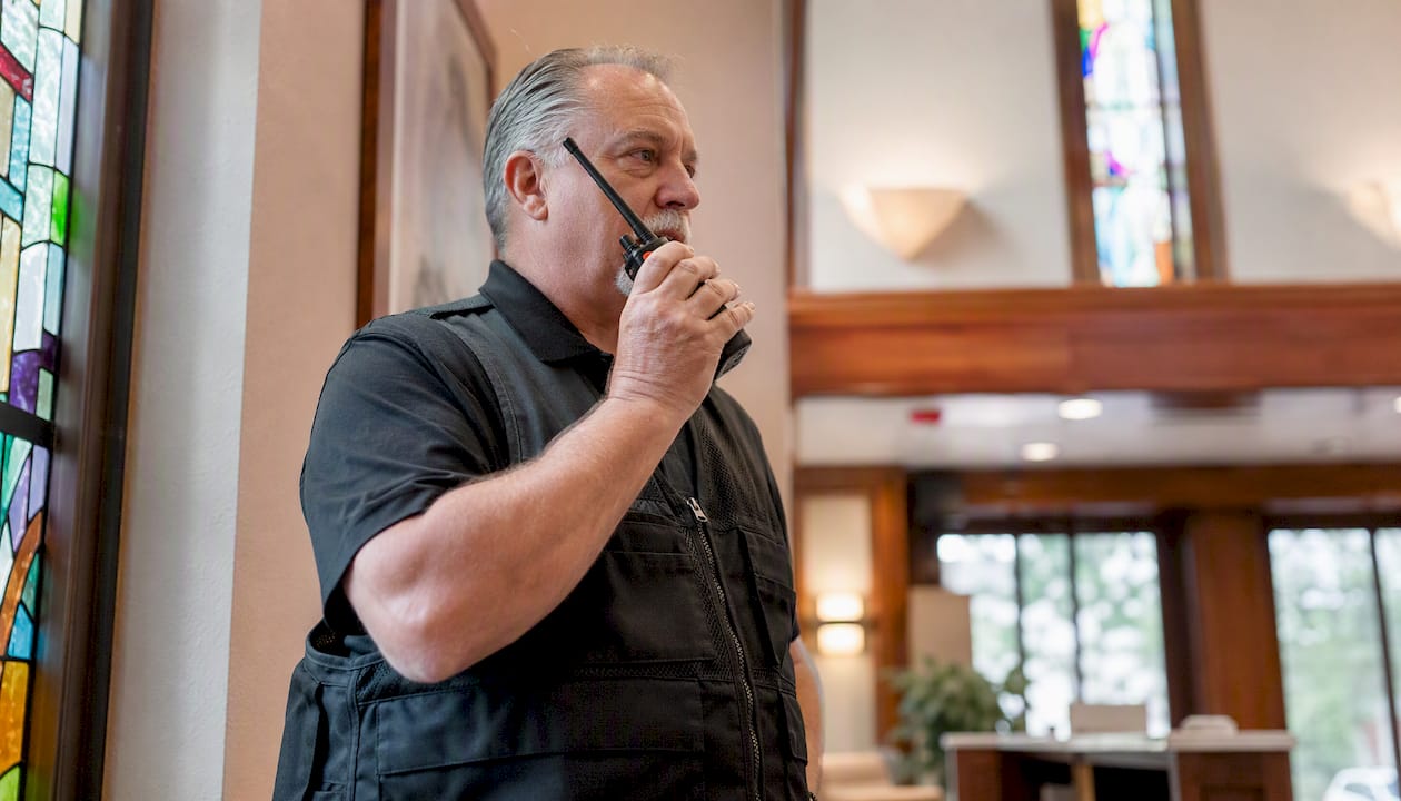 Security volunteer using radio in church drill