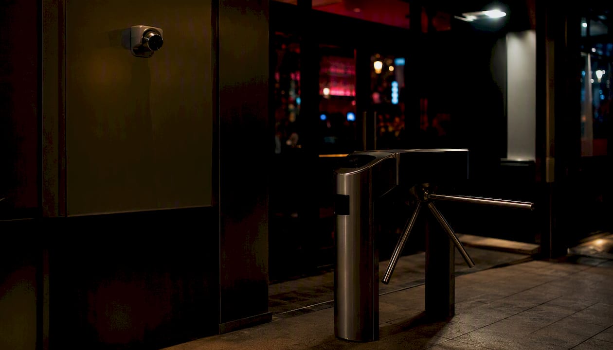 Bar entrance turnstile and CCTV at night