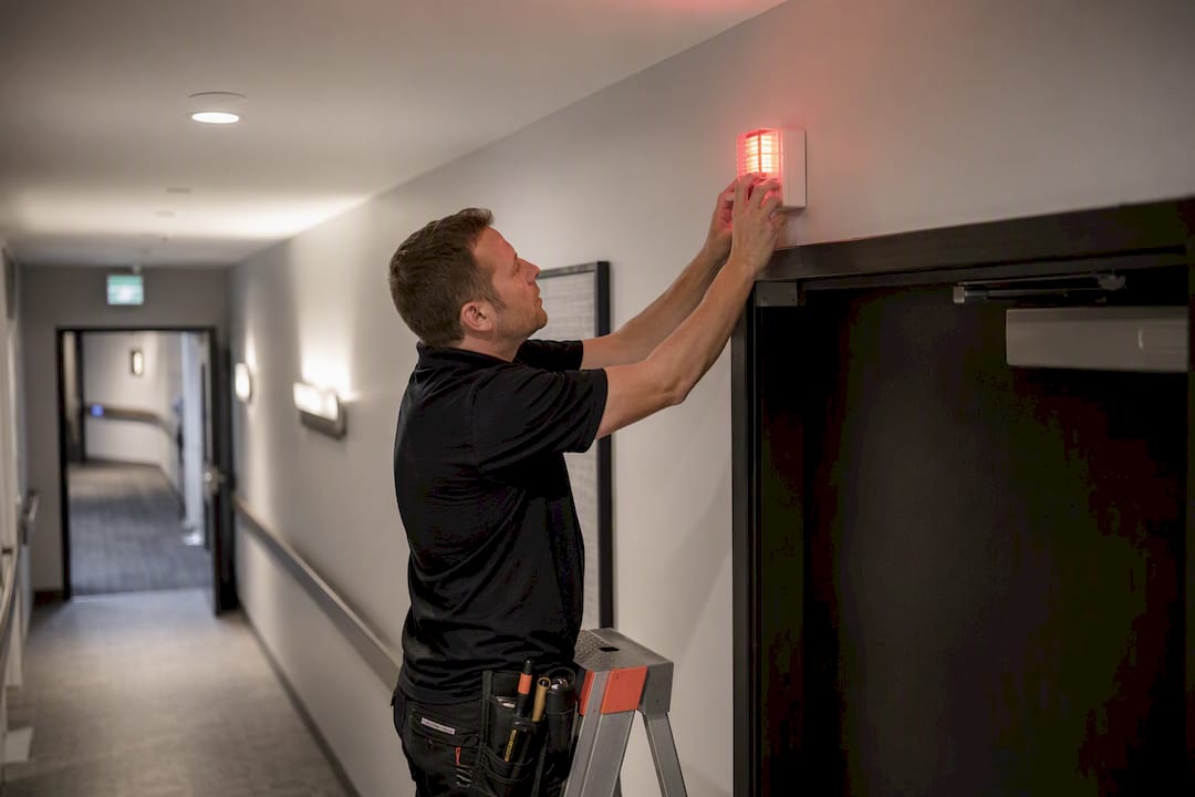 Hands installing visual alert beacon
