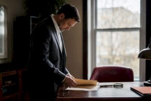 Investigator organizing search files on desk