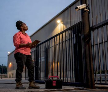 Consultant inspecting warehouse security camera